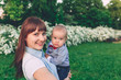© Yuliya - Portrait of a woman carrying little son at the park
