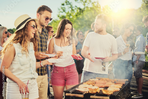 Fotografía Friends having outdoor party and eating barbecue