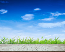 Empty Wooden Plank With Green Grass And Beautiful Blue Sky And Clouds, For Display Or Montage Product Or Other Background