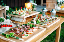 Beautiful Catering Banquet Buffet Table Decorated In Rustic Style In The Garden. Different Snacks, Sandwiches. Outdoor.