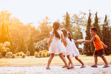 Wall Mural - Asian children holding hand and walking together in the park in vintage color tone