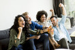 © BGStock72 - Friends watching TV , drinking cider and having fun in the room