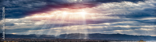 Beam of light through the clouds on the mountains - Rays of light shining through dark clouds , dramatic sky with cloud