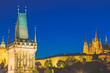 Prague Castle in Mala Strana district and Charles Bridge Tower during blue hour sunset in Czech Republic