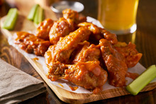 Sauced Buffalo Chicken Wings On Wooden Board With Celery