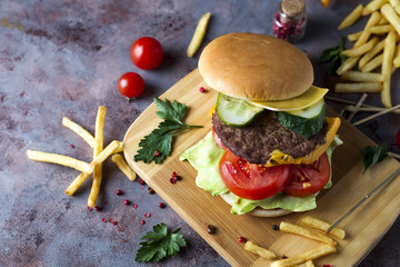 Hamburger with french fries, beer on a stone table