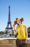 Fototapeta Paryż - smiling woman in bright blouse against Eiffel tower in Paris