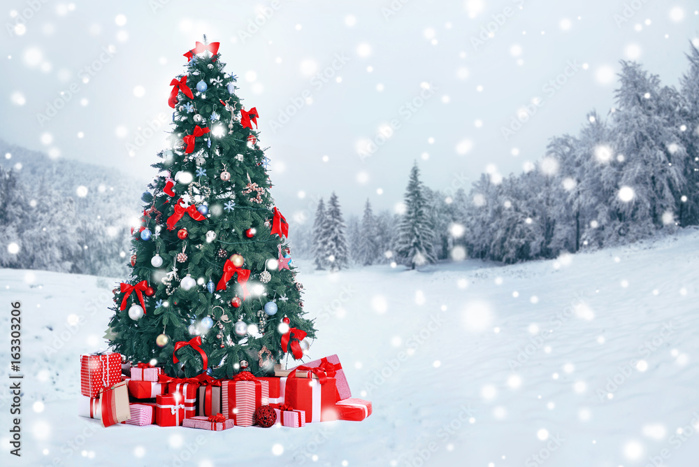 Decorated Christmas tree with gifts on nature background. Christmas ...