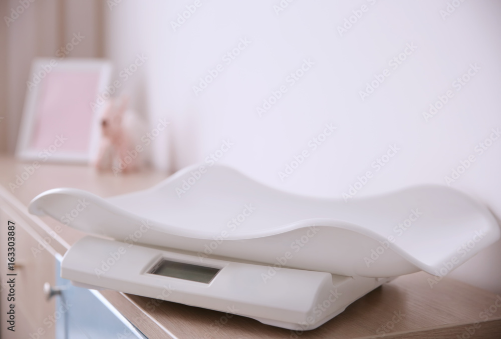 Digital baby scales on table in light room