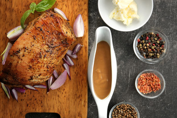 Wall Mural - Cutting board with delicious turkey, spices and gravy boat on grey table