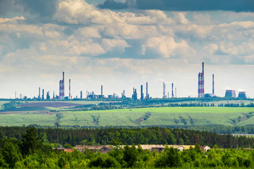 Industrial landscape with an oil refinery on the green hill