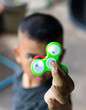© kaentian - Green hand spinner in hand.