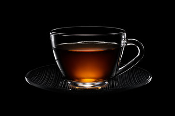 Glass cup of black tea isolated on black background