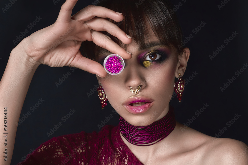 A charming girl with piercing in her nose. Septum. Beautiful woman with  bright makeup, burgundy dress pink lips and jar of glitters Stock Photo |  Adobe Stock