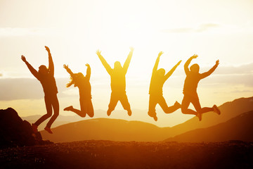 Wall Mural - Happy friends jumping sunset mountains