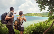 Travelers With Backpacks Watching Through Binoculars Enjoying Views Coast.