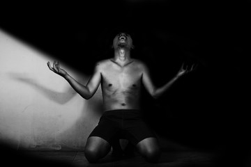 Wall Mural - depressed and hopeless man alone, shouting in the dark