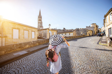 Wall Mural - Young woman tourist walking old street at the famous Saint Emilion village in Bordeaux region in France