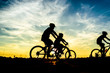 Silhouette of cyclist riding on bike at sunset.