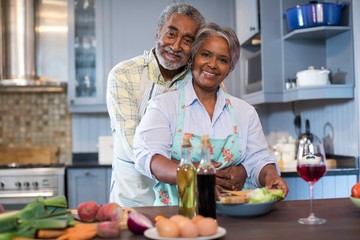 Wall Mural - Portriat of smiling senior couple preparing food