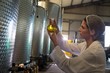 Female technician examining olive oil