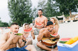 © hedgehog94 - Group of attractive young people enjoying in holiday, having fun and eating watermelon on beach.