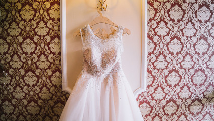 Wedding dress on hanger on a wall. 