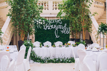 Wall Mural - Catering in restaurant. Wedding banquet. Wedding party. Restaurant event. Banquet, wedding, catering, celebration. Wedding restaurant. Served tables. Decor in green and white colors.