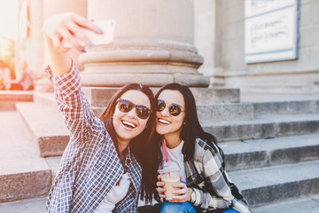 Two long hair brunette girls making selfie outdoor