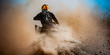 ATV rider creates a large cloud of dust and debris