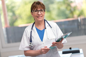 Wall Mural - Portrait of female doctor holding a clipboard