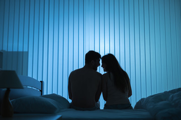 Wall Mural - The romantic couple sit on the bed. night time