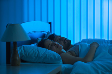 Wall Mural - The man and woman sleeping in the comfortable bed. night time, full grip focus