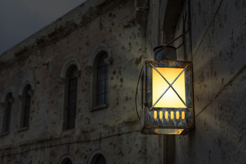 Bright glowing lantern illuminating the wall of an ancient building