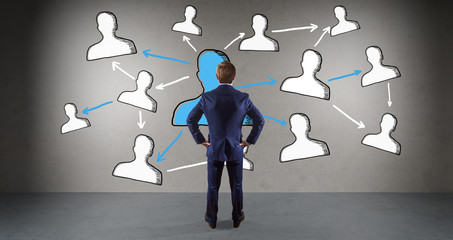 Wall Mural - Businessman watching social network sketch on a wall 3D rendering