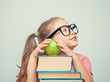 © Myst - beautiful cute little girl with books and green apple smiling and looking up