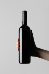 Wine Bottle Mock-Up - Male hands holding a wine bottle on a gray background