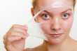 © Voyagerix - Woman removing facial peel off mask.