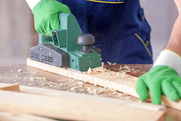 Wall Mural - Carpenter working with electric plane, closeup