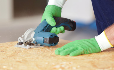 Wall Mural - Carpenter sawing timber, closeup