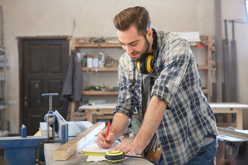 Poster - Carpenter applying marking onto drawing in workshop