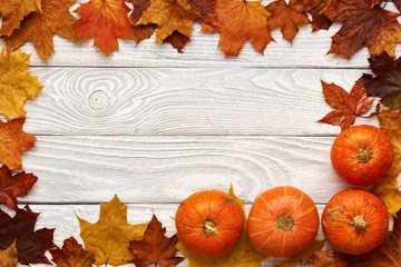 Canvas Print - Autumn leaves and pumpkins over old wooden background