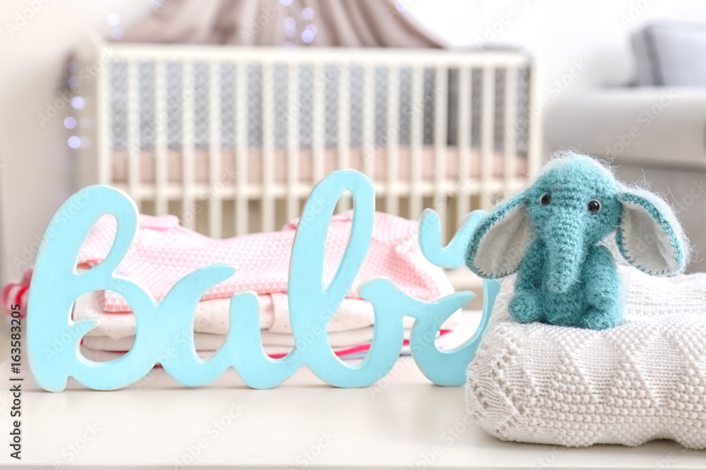 Cute baby elephant with decor on table in bedroom