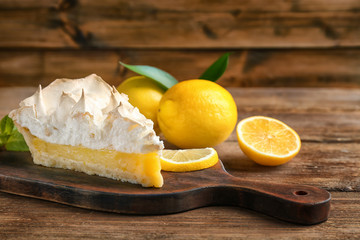 Poster - Piece of yummy lemon meringue pie on wooden table