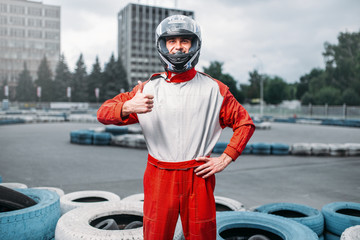 Wall Mural - Kart driver in helmet, karting track on background