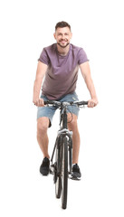 Wall Mural - Handsome young man riding bicycle on white background