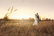 © Oleg Samoylov - Newlyweds standing in the field with ears