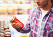 © Karanov images - Man holding beer can in a liquor store, choosing beer