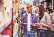 © Karanov images - Young smiling couple discussing what to buy in supermarket