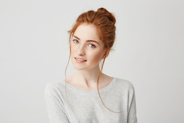 Wall Mural - Portrait of beautiful tender redhead girl smiling posing looking at camera over white background.